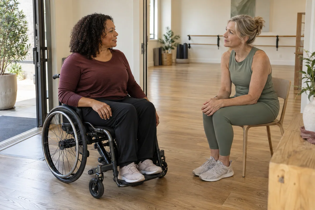 A wheelchair user and instructor discussing access and space in a movement studio.